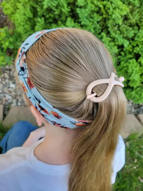 A child with a hair clip headband ponytail